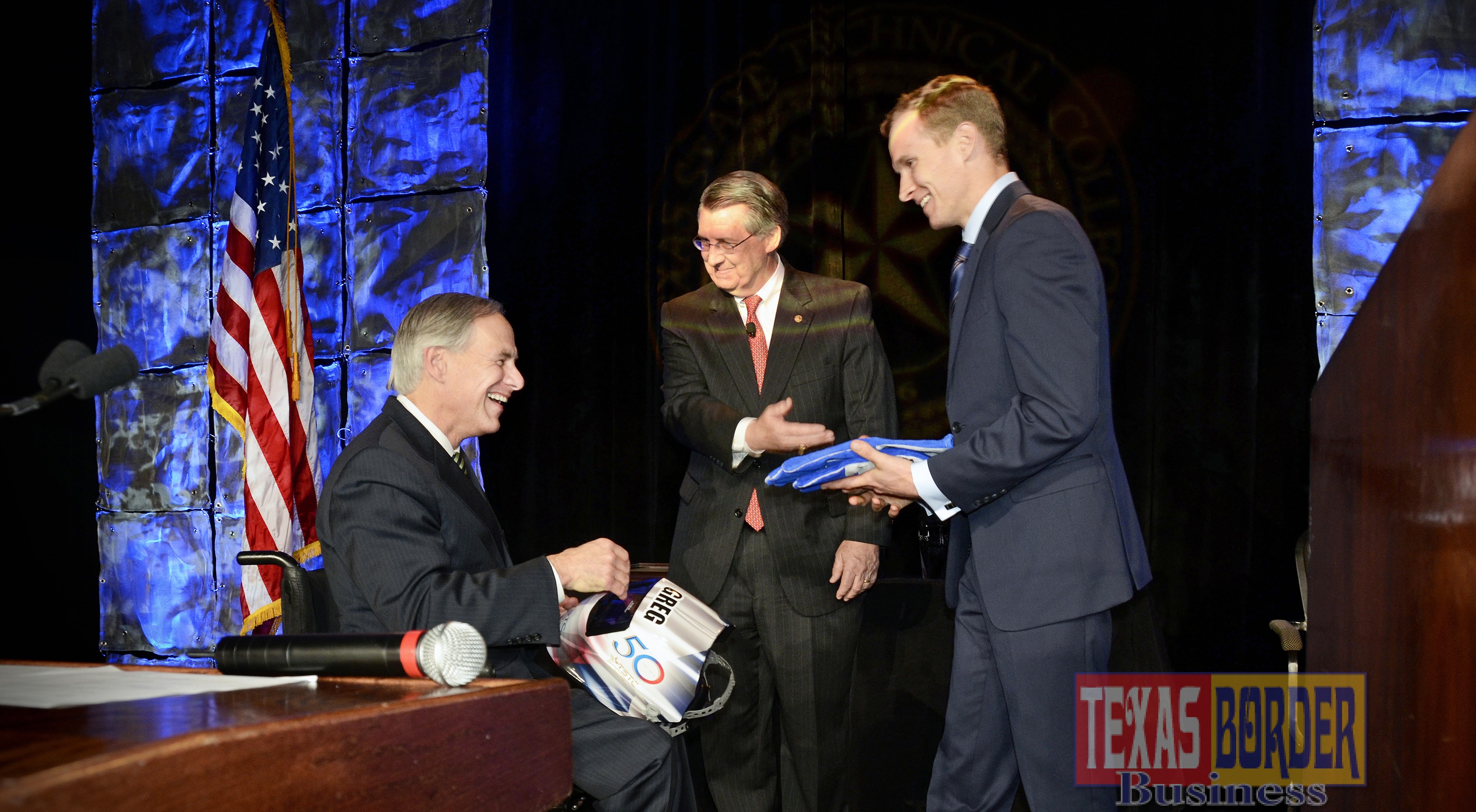 TSTC graduate Justin Friend and Chancellor Michael L. Reeser present Governor Greg Abbott with a personalized welding helmet and heat-resistant gloves at TSTC's 50th Anniversary Celebration.