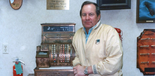 Joe LaMantia, Jr. next to an antique cash register. If was his preference for this picture to be taken next to the cash register. Photo taken on July 1988 and published in Texas Border Digest August 1988. Photo by Roberto Hugo González.