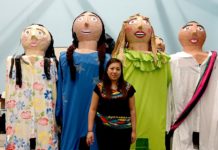 Lucero Rodriguez, president of the UTRGV Latino Theatre Initiatives, stands on a chair to pose with the UTRGV mojigangas, enormous puppets the student organization made this spring. The group is including the 11-foot-tall puppets in a play they’ll be performing in October in Brownsville and Edinburg. In the play, a girl’s homemade dolls come to life. (UTRGV Photo by Maria Elena Hernandez)