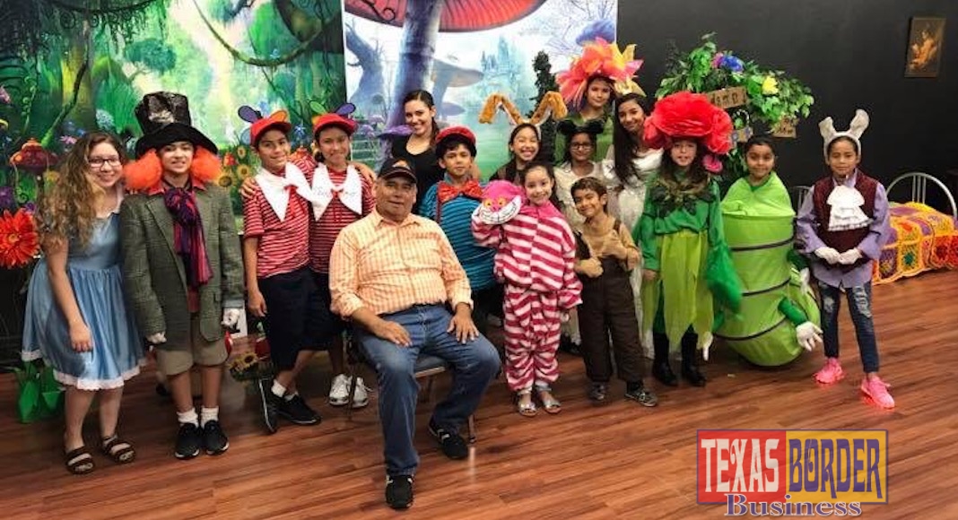 Kids acting teacher and director Juan Guerra sits with his cast from the play Alicia that was produced at Pharr Community Theater.