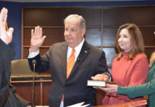Former McAllen Mayor Richard Cortez as he took the oath of office and his daughters, Sandy Chandrahasan and Laura Mangelschots witnessed the oath administered by District Judge Israel Ramon.