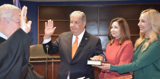 Former McAllen Mayor Richard Cortez as he took the oath of office and his daughters, Sandy Chandrahasan and Laura Mangelschots witnessed the oath administered by District Judge Israel Ramon.