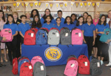 Longoria Middle School National Junior Honor Society members, Edinburg CISD administrators and Edinburg Rotarians are pictured with backpacks filled with school supplies that will be distributed to students at the campus.