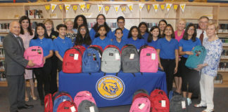 Longoria Middle School National Junior Honor Society members, Edinburg CISD administrators and Edinburg Rotarians are pictured with backpacks filled with school supplies that will be distributed to students at the campus.