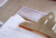 A COVID-19 Vaccination Record Card sits on a table at a vaccine clinic held in partnership between the Central Texas Food Bank and University of Texas in Austin on July 21, 2021. Photo Credit:  Sophie Park/The Texas Tribune