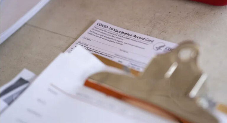 A COVID-19 Vaccination Record Card sits on a table at a vaccine clinic held in partnership between the Central Texas Food Bank and University of Texas in Austin on July 21, 2021. Photo Credit:  Sophie Park/The Texas Tribune