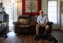 mas Garcia sits in his home with his dog, Patches, in Houston on Wednesday. Photo Credit:  Justin Rex for The Texas Tribune