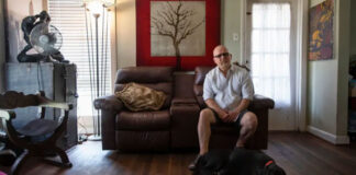 mas Garcia sits in his home with his dog, Patches, in Houston on Wednesday. Photo Credit:  Justin Rex for The Texas Tribune