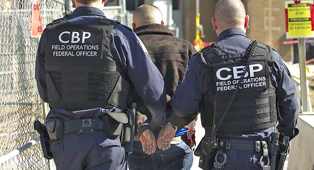 CBP officers escort wanted person to US port of entry.  USCBP Image