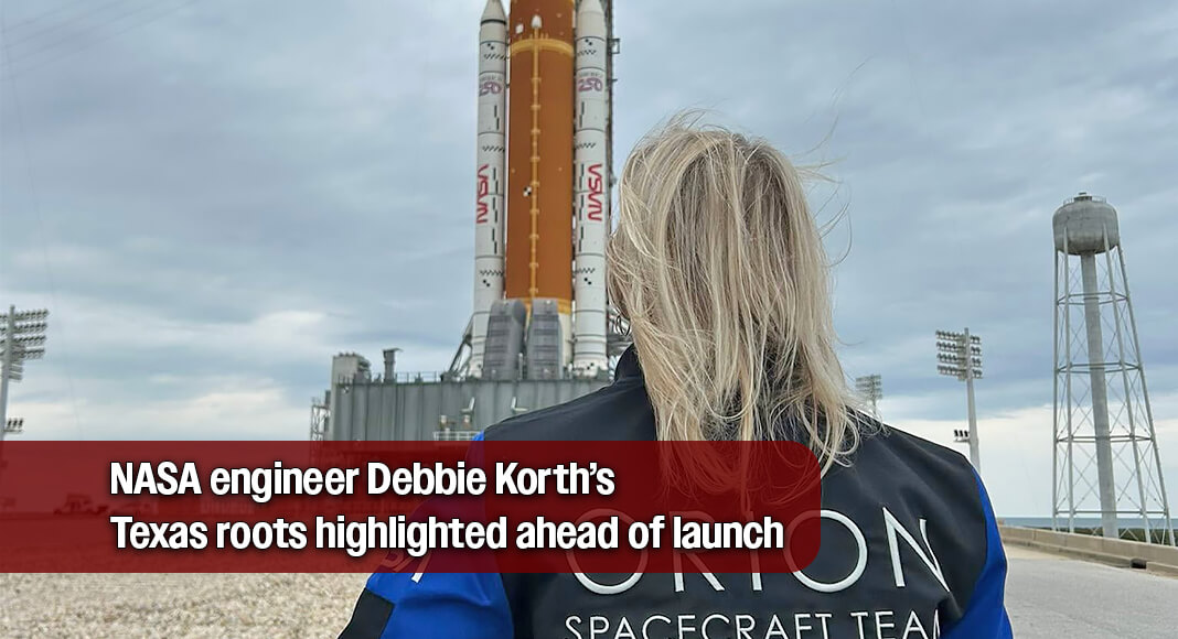 Debbie Korth stands facing the Orion spacecraft on the launch pad ahead of the Artemis II mission, observing final preparations. She wears a jacket with “ORION Spacecraft Team” printed across the back, reflecting her role in the program as the vehicle is readied for its journey around the Moon. Courtesy image